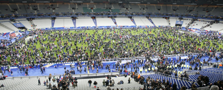 Spectators wait on the pitch of the Stade de France stadium in Seine-Saint-Denis, Paris suburb on 13 November, 2015 after a series of gun attacks occurred across Paris as well as explosions outside the national stadium where France was hosting Germany. Picture: AFP.