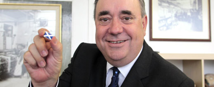 Alex Salmond, Scotland's leader of the Scottish National Party (SNP) and first minister, holds a pin with the Scottish flag during a visit to the Barrie Knitwear factory in Hawick, Scotland. Picture: AFP/Graham Stuart