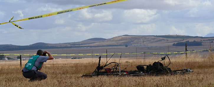 A police crime scene expert kneels next to the wreckage of the microlight that crashed at the Wintervogel airstrip near Malmesbury on 10 January 2013. Picture: Aletta Gardner/EWN