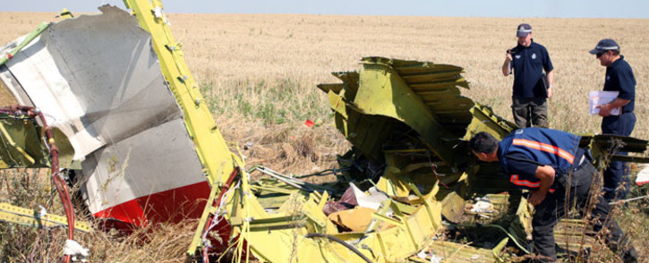 Australian and Dutch investigators examine a piece of debris of Malaysia Airlines Flight MH17, near the village of Hrabove, 100 km from Donetsk, Ukraine, on 1 August 2014. Picture: EPA.