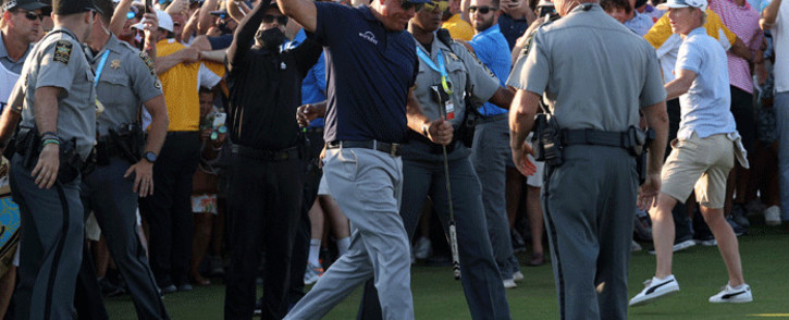 Phil Mickelson of the United States gives a thumbs up as he is assisted by security as he is followed up the 18th fairway by a gallery of fans during the final round of the 2021 PGA Championship held at the Ocean Course of Kiawah Island Golf Resort on May 23, 2021 in Kiawah Island, South Carolina. Picture: Patrick Smith/Getty Images/AFP

