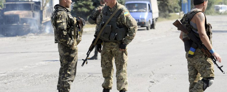 Ukrainian servicemen stand guard on 7 September, 2014 at a Ukrainian army checkpoint on the outskirts of the key southeastern port city of Mariupol, after an overnight bombing attack. Picture: AFP.