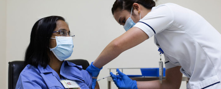 FILE: A handout picture taken by the Government of Dubai Media Office on 23 December 2020, shows a health worker administering a dose of the coronavirus vaccine to a nurse at a medical centre in the Dubai Emirate. Picture: AFP