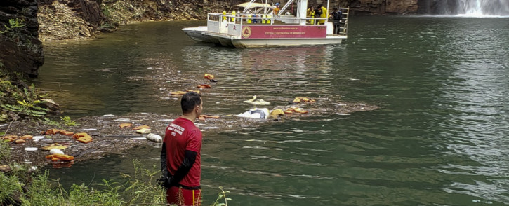   This handout picture shows firefighters during a rescue operation after a large rock fragment broke off a ravine and plunged onto several tourist boats. Picture: AFP