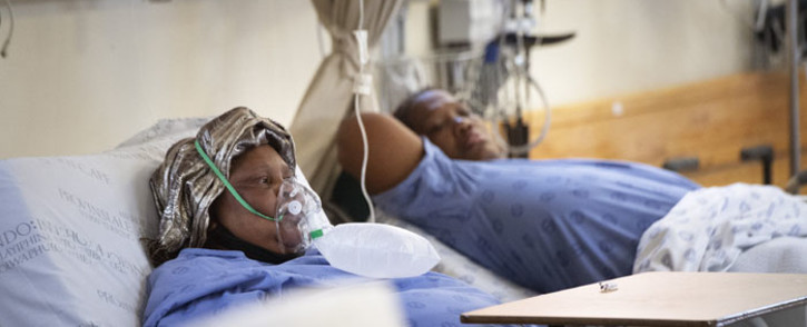 FILE: Two patients with COVID-19, one (L) breathing in oxygen, in the COVID-19 ward at Khayelitsha Hospital, about 35km from the centre of Cape Town, on 29 December 2020. Picture: RODGER BOSCH/AFP
