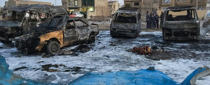 File: A picture taken with a mobile phone shows burnt vehicles at the scene of a blast by a massive car bomb, which killed dozens in a used car market in southern Baghdad. Picture: AFP