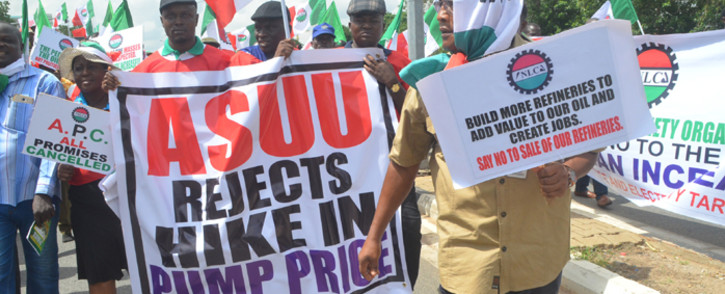 FILE: Workers and civil society groups carry placards as they march during a protest demanding that the government reinstate prices of fuel at 86.50 naira ($0.43, 0.38 euros) per litre in Lagos, on 18 May, 2016. Picture: AFP.