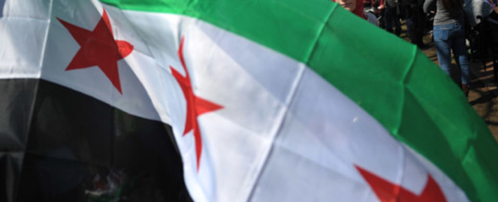 A woman behind a Syrian opposition flag during a rally against the Syrian government. Picture:  AFP.