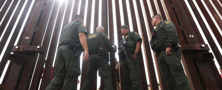 FILE: US border patrol agents lock the border wall gate at the conclusion of the Hugs Not Walls event on the US-Mexico border on 13 October 2018 in Sunland Park, New Mexico. Picture: AFP
