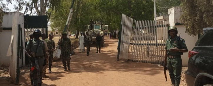 Nigerian soldiers and police officers stand at the entrance of the Federal College of Forestry Mechanisation in Mando, Kaduna state, on March 12, 2021, after a kidnap gang stormed the school shooting indiscriminately before taking at least 30 students around 9:30pm (2030 GMT) on March 11, 2021. Picture: Bosan Yakusak /AFP.