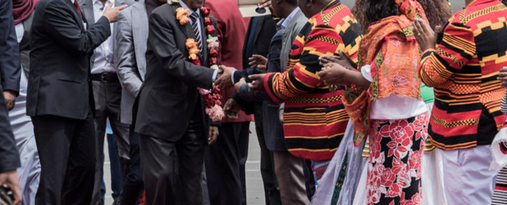 Eritrea’s Foreign Minister Osman Saleh Mohammed (C) walks with Ethiopia’s Prime Minister Abiy Ahmed (L) shaking hands with dignitaries as an Eritrean delegation for peace talks with Ethiopia arrives at the international airport in Addis Ababa on 26 June 2018. Picture: AFP