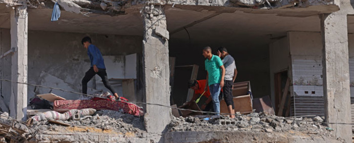 Palestinians inspect a building, destroyed by Israeli strikes, in Beit Hanun in the northern Gaza Strip on 21 May 2021. A ceasefire in the conflict between Israel and Palestinian militants in the Gaza Strip, controlled by Islamist group Hamas, came into effect after 11 days of airstrikes and rocket fire. Picture: Emmanuel Dunand/AFP