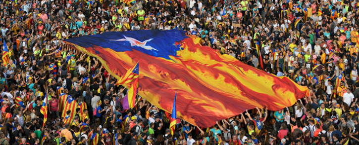 People hold Catalan pro-independence "estelada" flags during a demonstration in Barcelona, on 18 October 2019, on the day that separatists have called a general strike and a mass rally. Picture: AFP