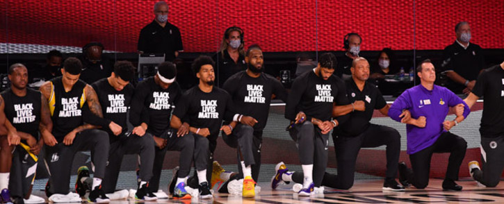 The Los Angeles Lakers and the LA Clippers kneel during the National Anthem prior to a game on 30 July 2020 at The Arena at ESPN Wide World Of Sports Complex in Orlando, Florida. Picture: AFP