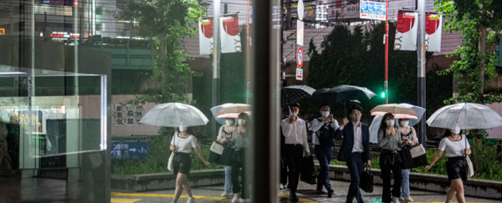 People walk on a street in Tokyo's Shinjuku district as Japan announces a new virus state of emergency stretching throughout the Tokyo Olympics, on 18 July 2021. Picture: Philip FONG/AFP