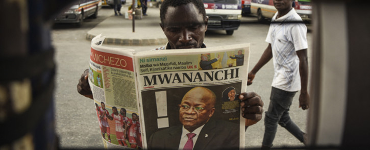A man reads a newspaper with a headline announcing the death of Tanzania's President John Magufuli in Dar es Salaam, on 18 March 2021. Picture: AFP.