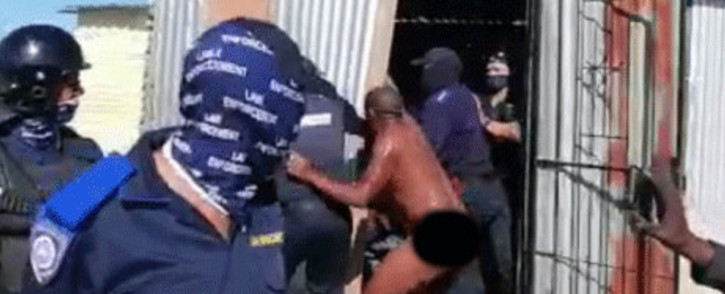 A screengrab from a video taken on 1 July 2020 in which Cape Town law enforcement officials evict a naked man from his Empolweni home in Khayelitsha.
