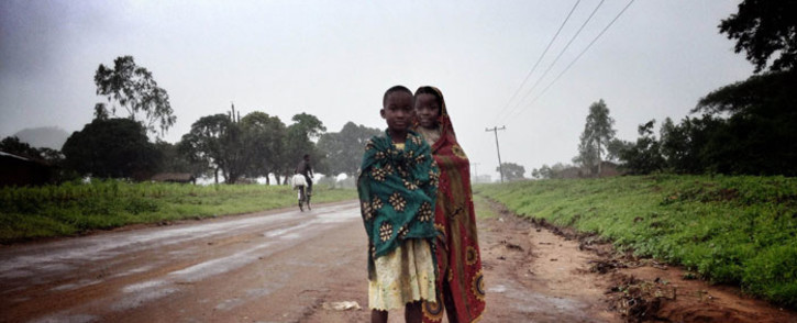 FILE: Two young girls in the Chiradzulu District use fabric to shelter from the drizzle on 22 January 2015. Picture: EWN.