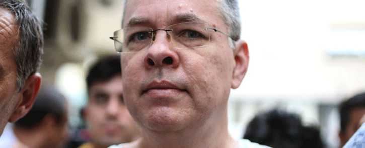 In this file photograph taken on 25 July 2018, US pastor Andrew Craig Brunson is escorted by Turkish plain clothes police officers to his house in Izmir. Picture: AFP