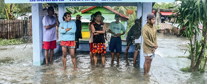 Residents stand in a flooded area in the coastal town of Guiuan, central Philippines' Eastern Samar province on December 16, 2021, after Super Typhoon Rai passed. Picture: Alren Beronio / AFP.