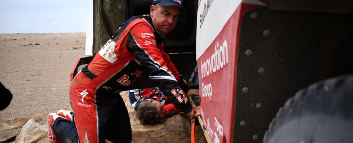 FILE: Toyota's driver Giniel De Villiers of South Africa kneels next to his car after stopping due to technical problems during Stage 3 of the Dakar 2019. Picture: AFP