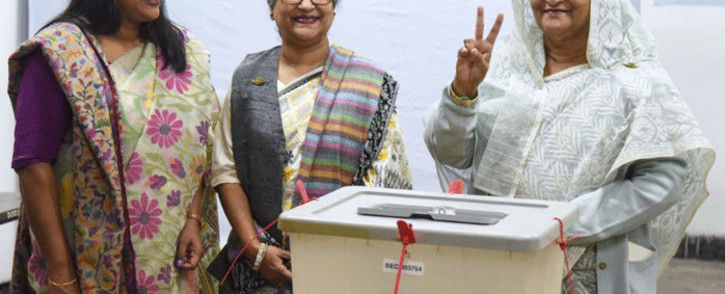 FILE: Bangladeshi Prime Minister Sheikh Hasina (R) flashes the victory symbol after casting her vote, as her daughter Saima Wazed Hossain and her sister Sheikh Rehana look on at a polling station in Dhaka on 30 December 2018. Picture: AFP