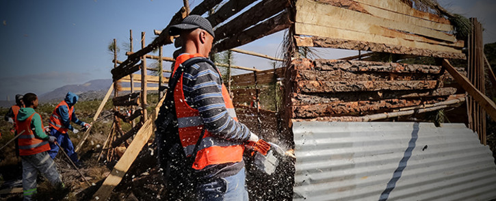 The eviction unit uses chainsaws and crowbars to demolish shacks in Grabouw where residents protested on 10 May 2016. Picture: Thomas Holder/EWN