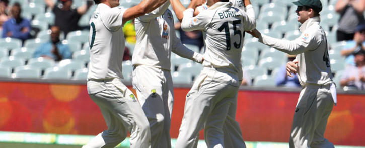 Australia's Pat Cummins (L) celebrates with teammates after dismissing India's captain Virat Kohli as India is all out for only 36 runs on the third day of the first cricket Test match between Australia and India played in Adelaide on 19 December 2020. Picture: AFP
