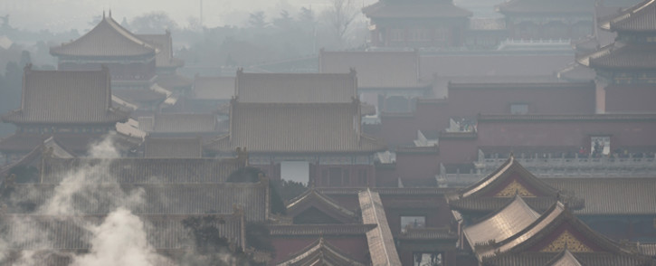 Steam rises behind a wall of the Forbidden City, once the home of Chinas emperors, on a polluted day in Beijing on 19 December 2015. The Chinese capital issued its second-ever red alert for pollution and put its emergency response plan into action, ordering factories to close and pulling half of all private cars off the streets. Picture: AFP.