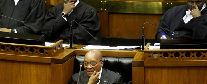 President Jacob Zuma sits down as he is interrupted trying to give his State of the Nation Address on 11 February 2016. Picture: AFP.