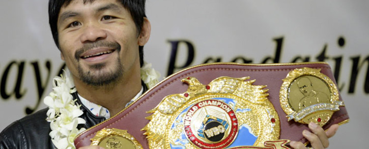 This file photo taken on April 14, 2016 shows Filipino boxer Manny Pacquiao holding his championship belt as he arrives at Manila International Airport in Manila. Picture: AFP