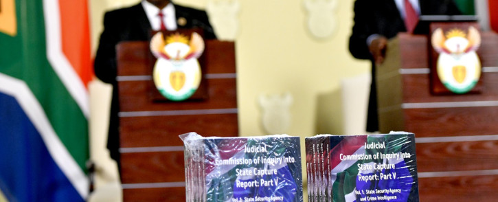 Chief Justice Raymond Zondo and President Cyril Ramaphosa stand as a backdrop to hard copies of the final parts of the State Capture report on Wednesday, 22 June 2022. Picture: GCIS