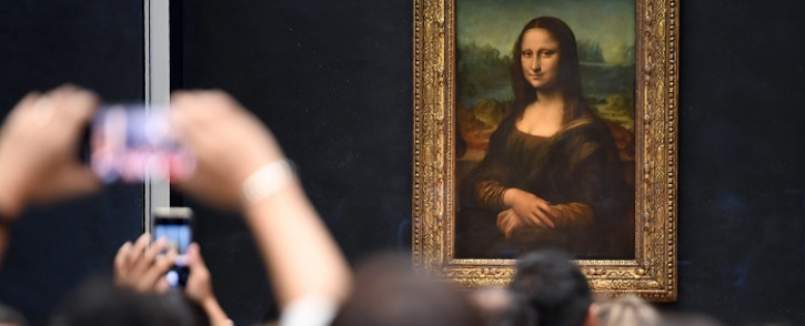 Visitors take pictures in front of 'Mona Lisa' after it was returned at its place at the Louvre Museum in Paris on 7 October 2019. Picture: AFP