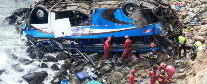 Handout picture released by Peruvian agency Andina showing rescuers, police and firefighters working at the scene after a bus plunged around 100 meters over a cliff after colliding with a truck on a coastal highway near Pasamayo, around 45 km north of Lima, and killing at least 25 people on 2 January, 2018. Picture: AFP.