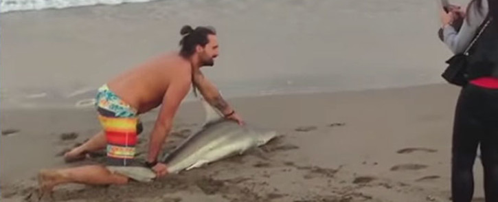 A man dragged a shark out of the water on a Florida beach to take pictures. Picture: Screengrab via The Young Turks/YouTube.