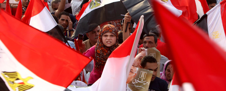 Hundreds of supporter of presidential candidate Ahmed Shafiq, the last prime minister of ousted leader Hosni Mubarak, hold up the national flag as they demonstrate in Nasr city on the outskirts of Cairo, on June 23, 2012. Tensions soared in Egypt a day before the result of a divisive presidential election and as the Muslim Brotherhood sparred with the ruling generals over what it sees as a military power grab. Picture: AFP
