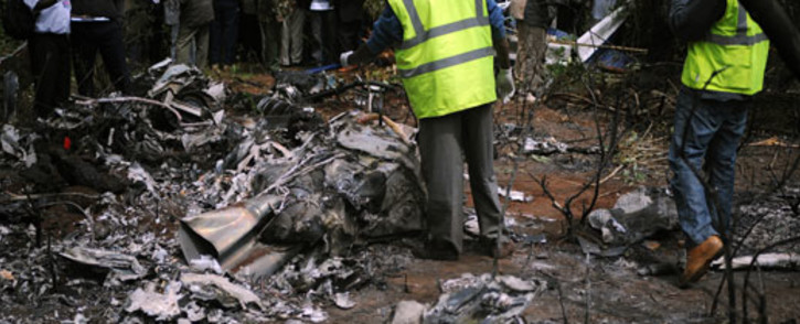 Kenyan forensic experts collect evidence at the site of a police helicopter crash near a charred body on June 10, 2012 in the Ngong hills outside Nairobi. Kenya's Internal Security Minister George Saitoti was killed in the crash. Picture: AFP