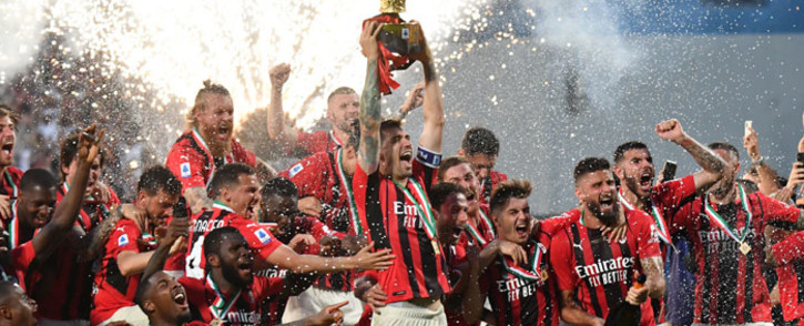 AC Milan defender Alessio Romagnoli (C) and AC Milan's players celebrate with the winner's trophy after AC Milan won the Italian Serie A football match between Sassuolo and AC Milan, securing the "Scudetto" championship on 22 May 2022 at the Mapei - Citta del Tricolore stadium in Sassuolo. Picture: Tiziana FABI / AFP