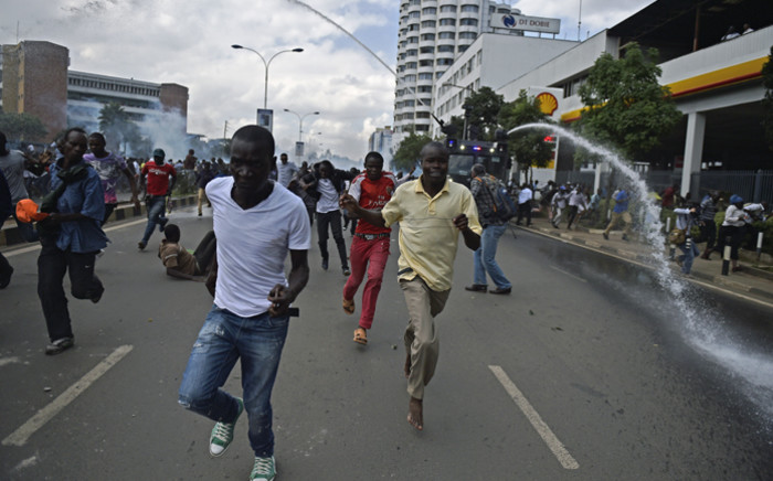Protestors run from water canons after Kenya's opposition supporters demonstrated in Nairobi, on 16 May, 2016. Picture: AFP.