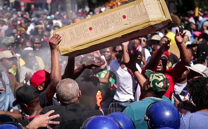 Fees2017 protesters fling a coffin symbolising Blade Nzimandes coffin into a police barricade outside parliament. Picture: Anthony Molyneaux/EWN