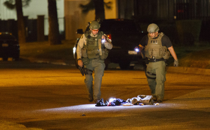 Law enforcement officers investigate a suspicious bag, later found not to be a threat, on Victoria Avenue after a mass shooting at the Inland Regional Center on 2 December, 2015 in San Bernardino, California. Picture: AFP.