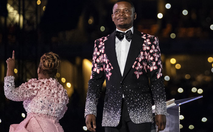 FILE: Pastor Shepherd Bushiri (R), also known as Prophet Bushiri from the Enlightened Christian Gathering (ECG), stands on stage while his wife, Mary Bushiri, speaks to worshippers during the United Prayers Crossover at the FNB Stadium in Soweto on 1 January 2020. Picture: AFP