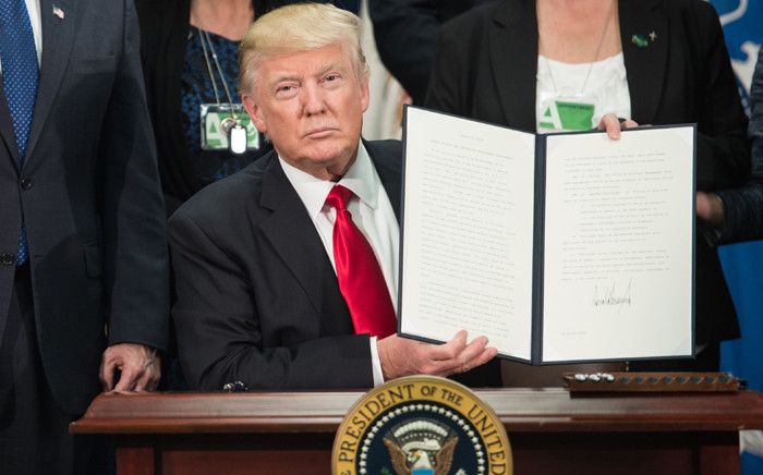 FILE: US President Donald Trump signs an executive order to start the Mexico border wall project at the Department of Homeland Security facility in Washington on 25 January 2017. Picture: AFP.
