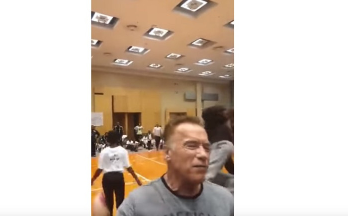 A screenshot of a fan kicking Arnold Schwarzenegger in the back at the Arnold Classic Africa Festival in Sandton. Picture: World's Strongest Fan/Youtube