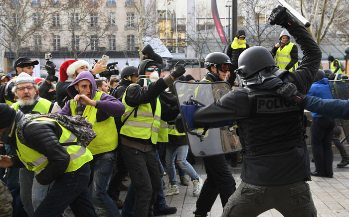 FILE: Riot police clash with men wearing "yellow vests" (gilets jaunes) protestors on 8 December 2018 near the Arc de Triomphe in Paris during a protest against rising costs of living they blame on high taxes. Picture: AFP
