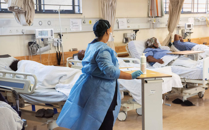 FILE: A hospital worker walks amongst patients in the COVID-19 ward at Khayelitsha Hospital, about 35km from the centre of Cape Town, on 29 December 2020. Picture: AFP.
