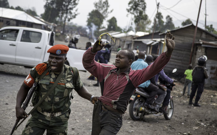 A man is arrested by a member of the military police after people attempted to block the road with rocks, in the neighbourhood of Majengo in Goma, eastern Democratic Republic of the Congo. Picture: AFP.