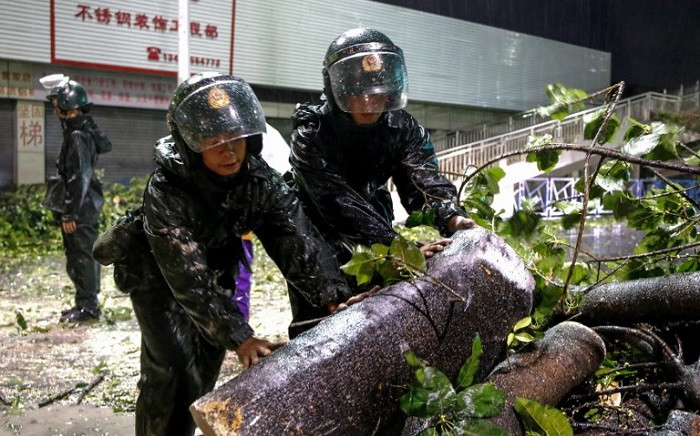 Paramilitary police officers clean up damaged trees and branches on road after super Typhoon Mangkhut in Zhongshan, south China's Guangdong province early on 17 September, 2018. Picture: AFP