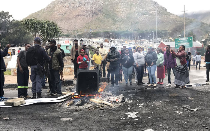 Imizamo Yethu residents sing and dance while police try to calm the situation. Picture: Monique Mortlock/EWN