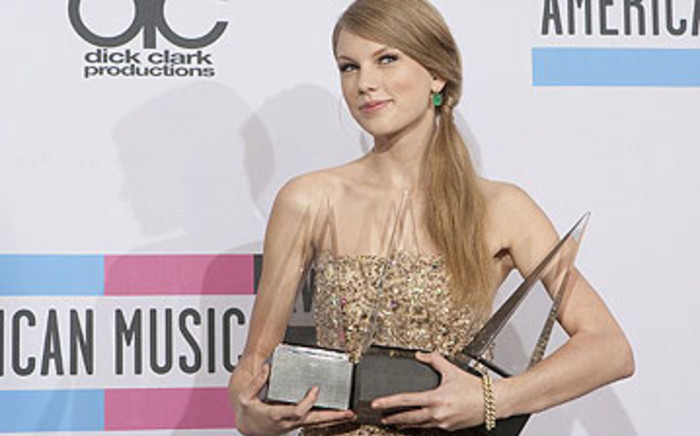 Taylor Swift poses with her three awards during the 2011 American Music Awards on November 20, 2011. Picture: AFP